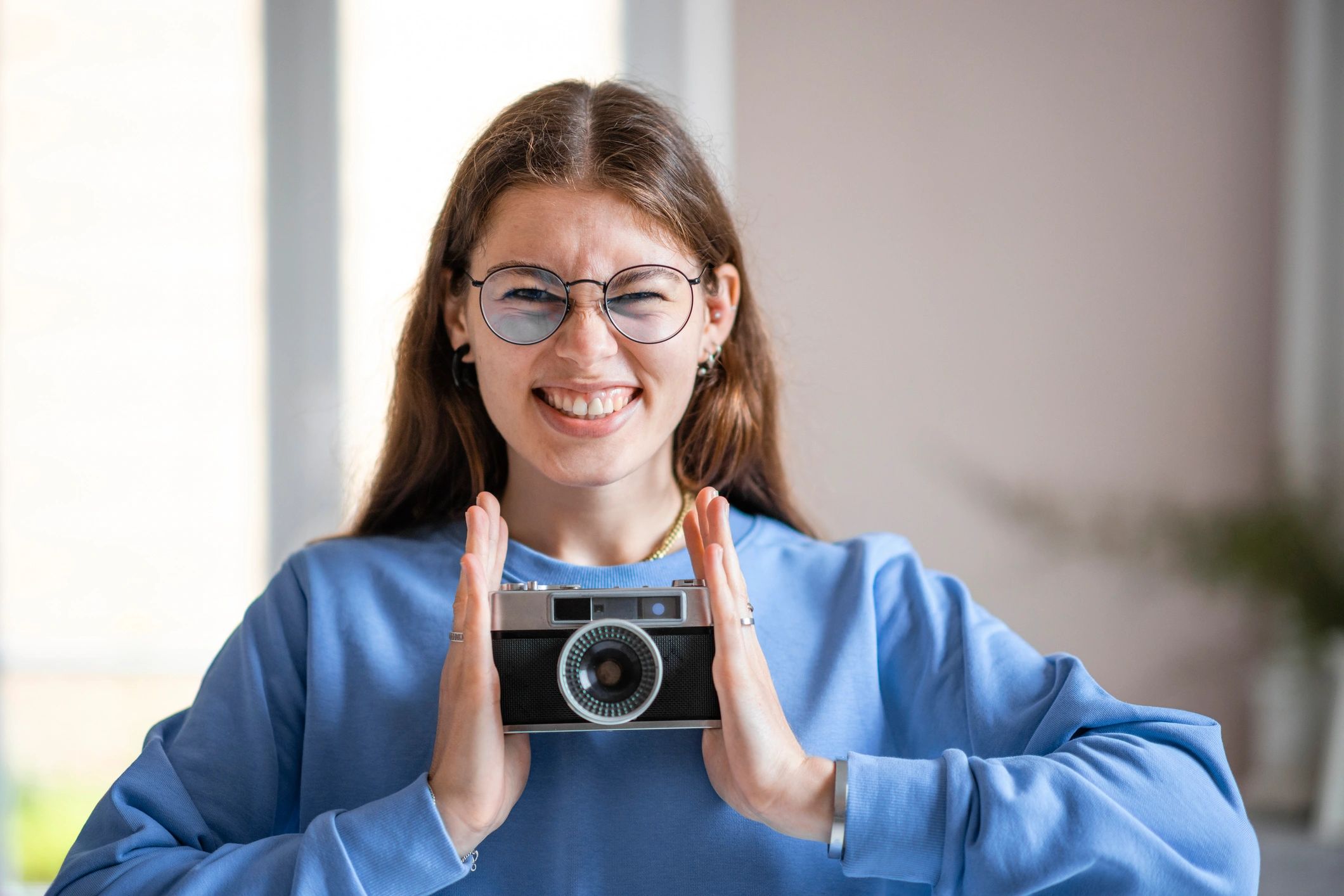 Photographer smiling with camera in studio