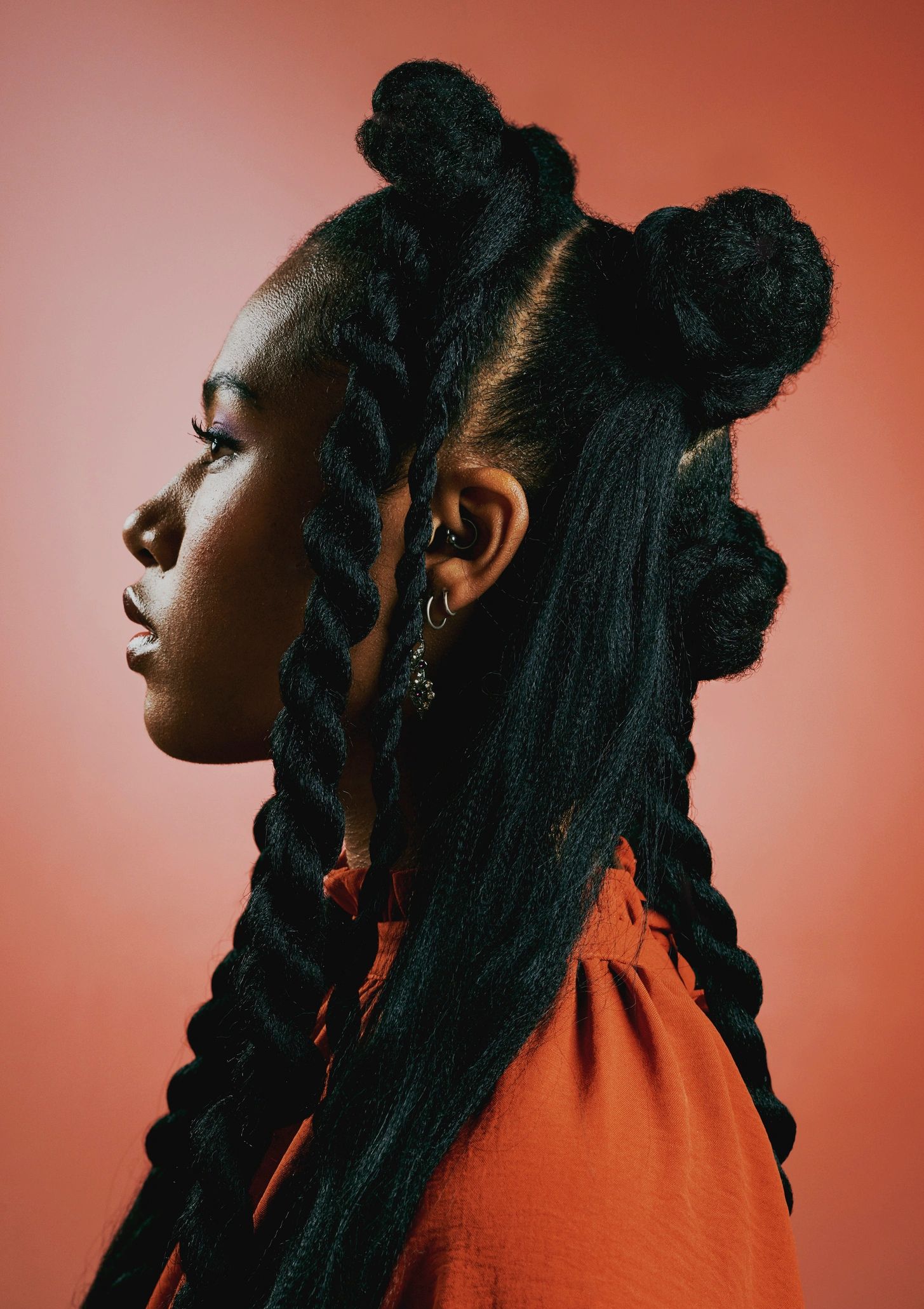 Confident woman with braided hairstyle in a creative studio portrait